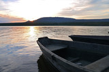 Fototapeta Pomosty - Boats on a background of mountains and a golden sunset. Lake Zyuratkul, the Zyuratkul national Park, Chelyabinsk oblast, Russia.