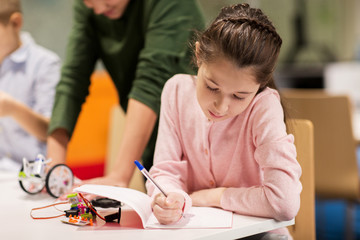 Wall Mural - happy girl writing to notebook at robotics school