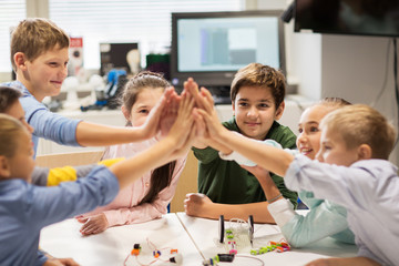 Wall Mural - happy children making high five at robotics school