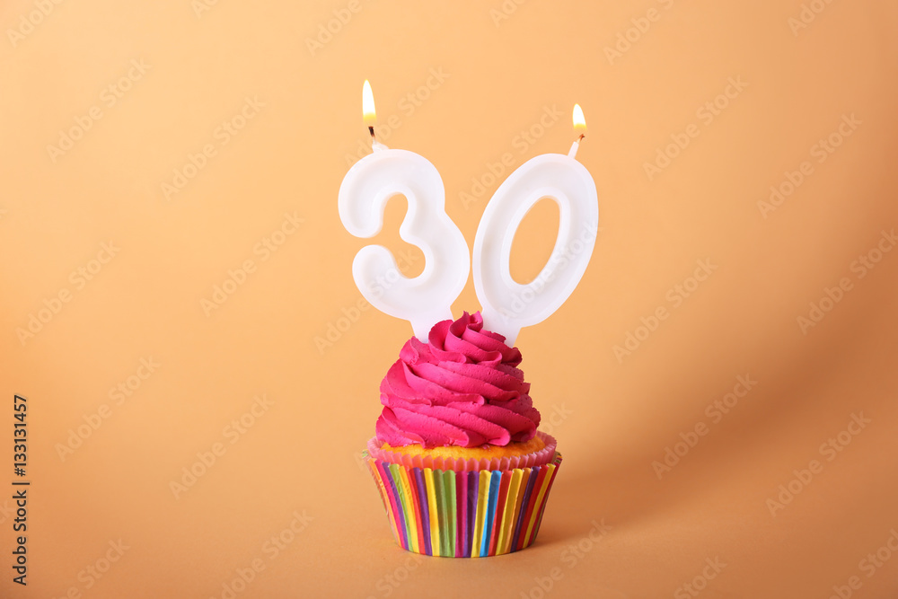 Birthday cupcake with candles on color background