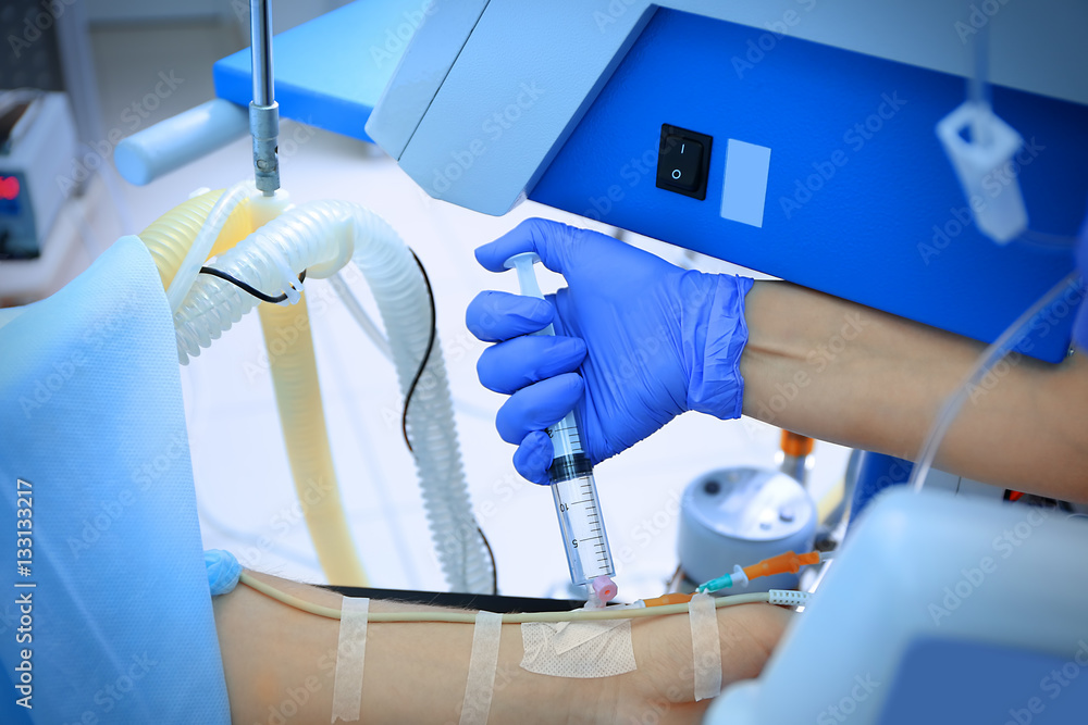 Patient receiving injection from doctor during operation in clinic, closeup