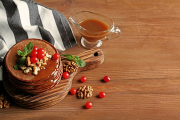 Sticker - Tasty chocolate pancakes with  viburnum and nuts on wooden board