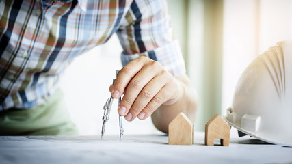 close-up of person's hand drawing plan on blue print with archit