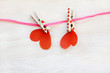 special power of love/ couple of paper hearts hanging on pink ribbon retained by clothespins 