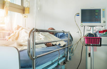 Close Up Bed Of  Hospital Ward Room During Elderly Patient Sleep With Digital Device For Measuring Blood Pressure Monitor