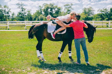 couple and horse at a farm ridding and kissing each other.