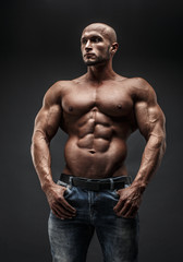 Wall Mural - bodybuilder posing. Beautiful sporty guy male power. Fitness muscled man