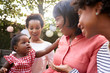 © Monkey Business - Multi generation female family members gathered in a garden