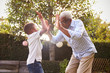 © Monkey Business - Black grandfather playing with his grandson in a garden