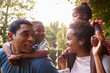 © Monkey Business - African American parents giving children piggyback rides