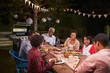© Monkey Business - Adult black family enjoying dinner together in their garden