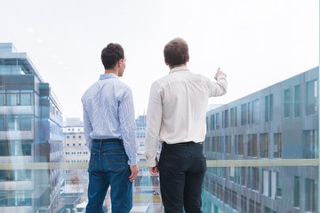 Two business people looking at horizon, projects, visions, collaboration