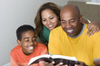 © digitalskillet1 - African American multicultural family reading The Bible.
