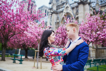 Wall Mural - Romantic couple in Paris with cherry blossom trees