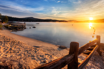 Wall Mural - Mist rises from Merrymeeting Lake, as seen from the beach by the marina boat launch, New Durham, New Hampshire right after sunrise on a summer morning