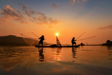 Silluate fisherman and boat in river on during sunrise,Thailand