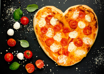 Wall Mural - Heart-shaped pizza with cherry tomatoes, mozzarella and basil