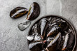 Fresh uncooked big mussels on ice. Slate background. Top view