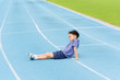 © TinPong - Young Asian boy sit on blue track in the stadium