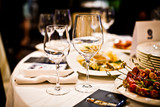 Fototapeta  - Empty wine glasses on a served table in a fancy restaurant