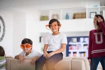 Wall Mural - Funny kids with silly glasses on eyes at home