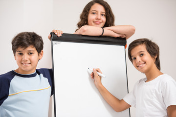 Wall Mural - Group of kids holding white board as copy space