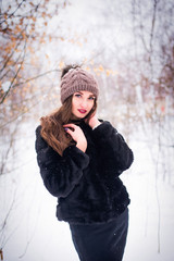 charming young beautiful girl in winter forest
