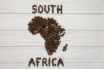  Map of the Africa made of roasted coffee beans  on white wooden textured background with space for text