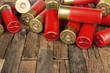12 gauge red hunting cartridges for shotgun on wooden background. Macro shot.