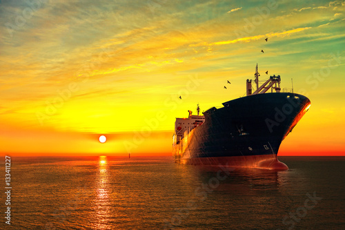 Fotomural Oil tanker ship at sea on a background of sunset sky.