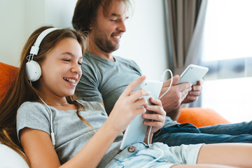 Father and child playing on tablet