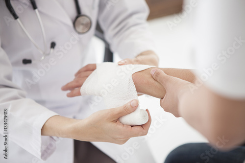 Fotografía The doctor is wrapping a bandage in the hand of a man