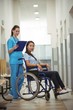 © WavebreakMediaMicro - Female nurse assisting patient on wheelchair in corridor