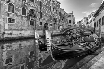 Black and white view of typical traditional gondolas parked in a Venetian canal, Fondamenta dei Preti, Venice, Italy