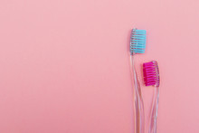 Two Pink And Blue Toothbrushes On Pink Background