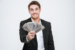 © Drobot Dean - Cheerful businessman standing at studio holding money