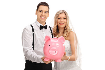 Canvas Print - Happy newlywed couple holding a piggybank