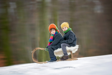 Canvas Print - Two Happy little children, boys, playing outdoors in snowy park