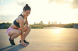 © Flamingo Images - Woman ready to run while squatting near ground