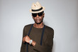 © Drobot Dean - Young african man wearing hat and glasses standing in studio.