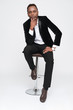 © Drobot Dean - Young african businessman sitting on stool.