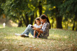 © BalanceFormCreative - Mother and daughter relaxing in park. She's reading a fairy tale to her daughter.
