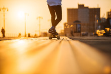 Young man riding longboard on the bordwalk, feet only