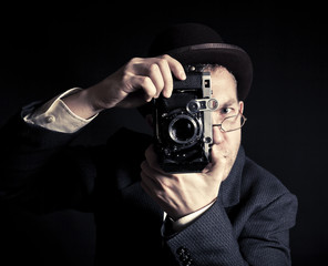 Young and attractive photographer in vintage suit and with retro