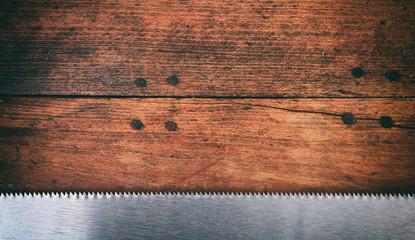 Wall Mural - Hand saw blade on wooden background