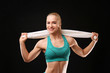 © Africa Studio - Young athletic woman with towel on black background