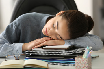 Canvas Print - Tired young woman sleeping in office