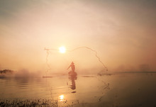 Silhouette Of Traditional Fisherman Throwing Net Fishing Lake At