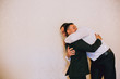 © nataliakabliuk - Laughing groomsmen touch groom's shoulders while they stand in the room