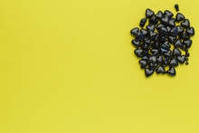 Black Hearts Of Beads On A Yellow Background